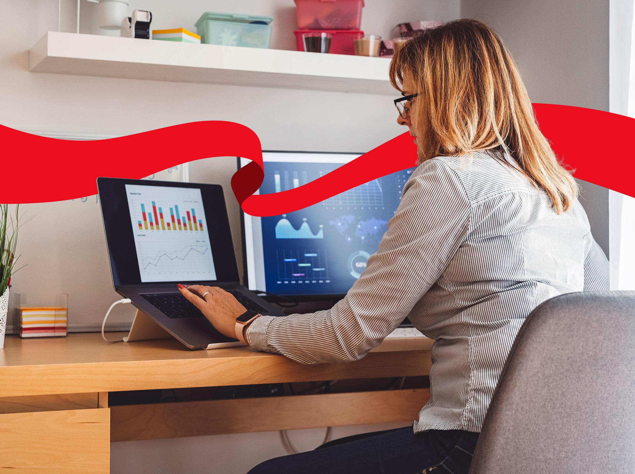 Woman comparing data on laptop and desktop computers