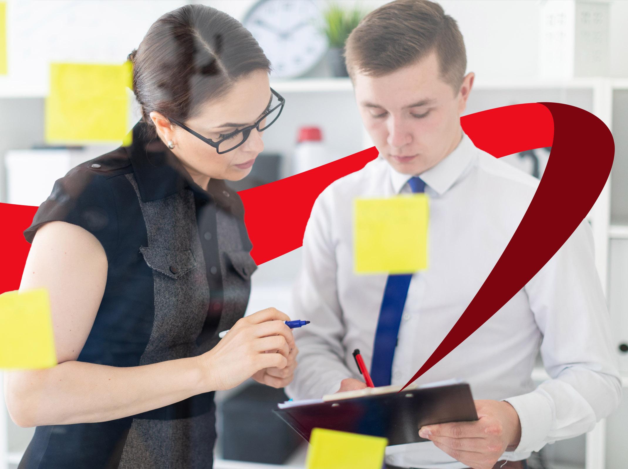 A manager coaches an employee in an office, demonstrating skills learned in the AI for Managers course.