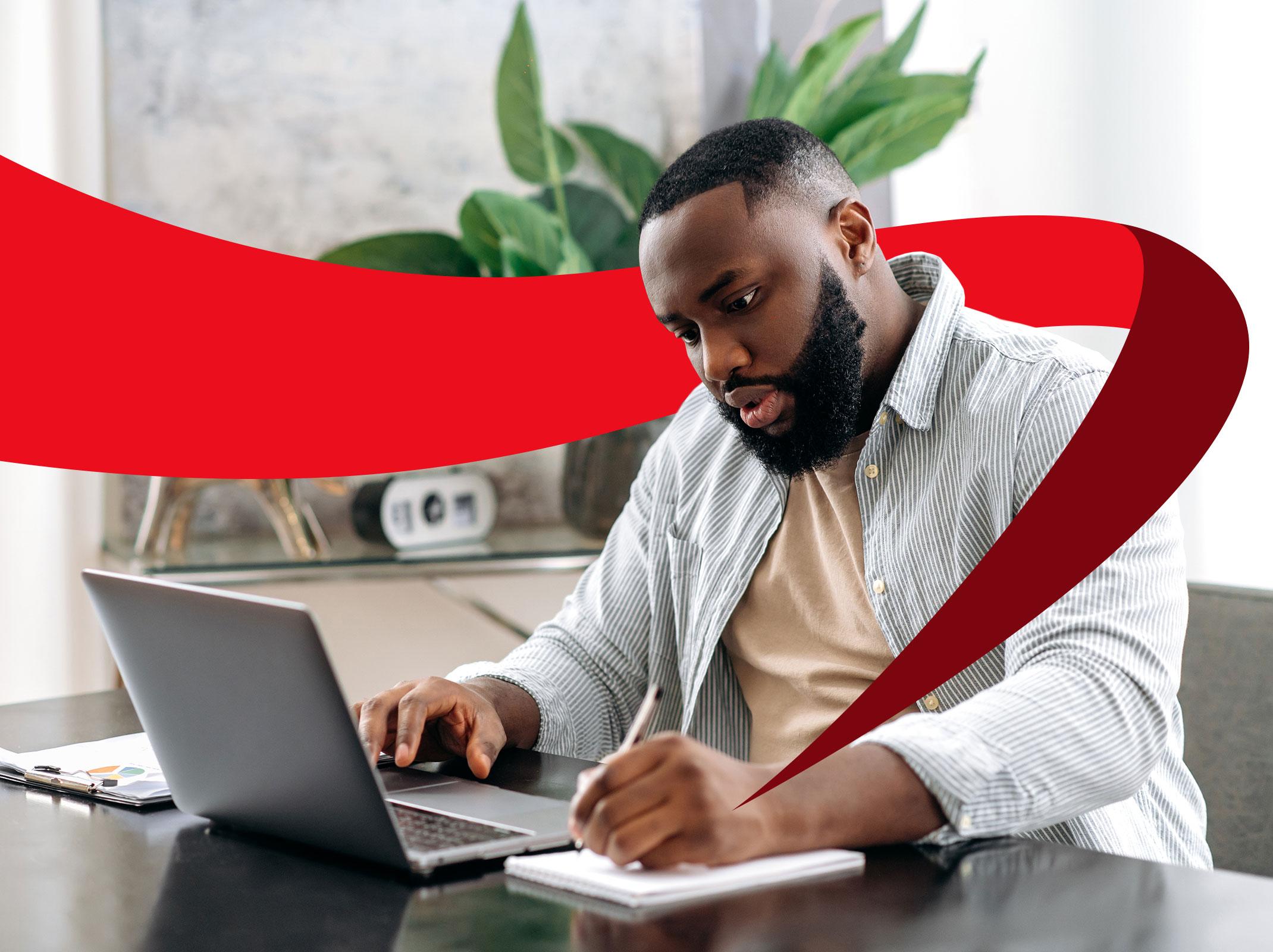 Business person sitting at desk in modern office using the business writing and grammar skills learned in professional development training.