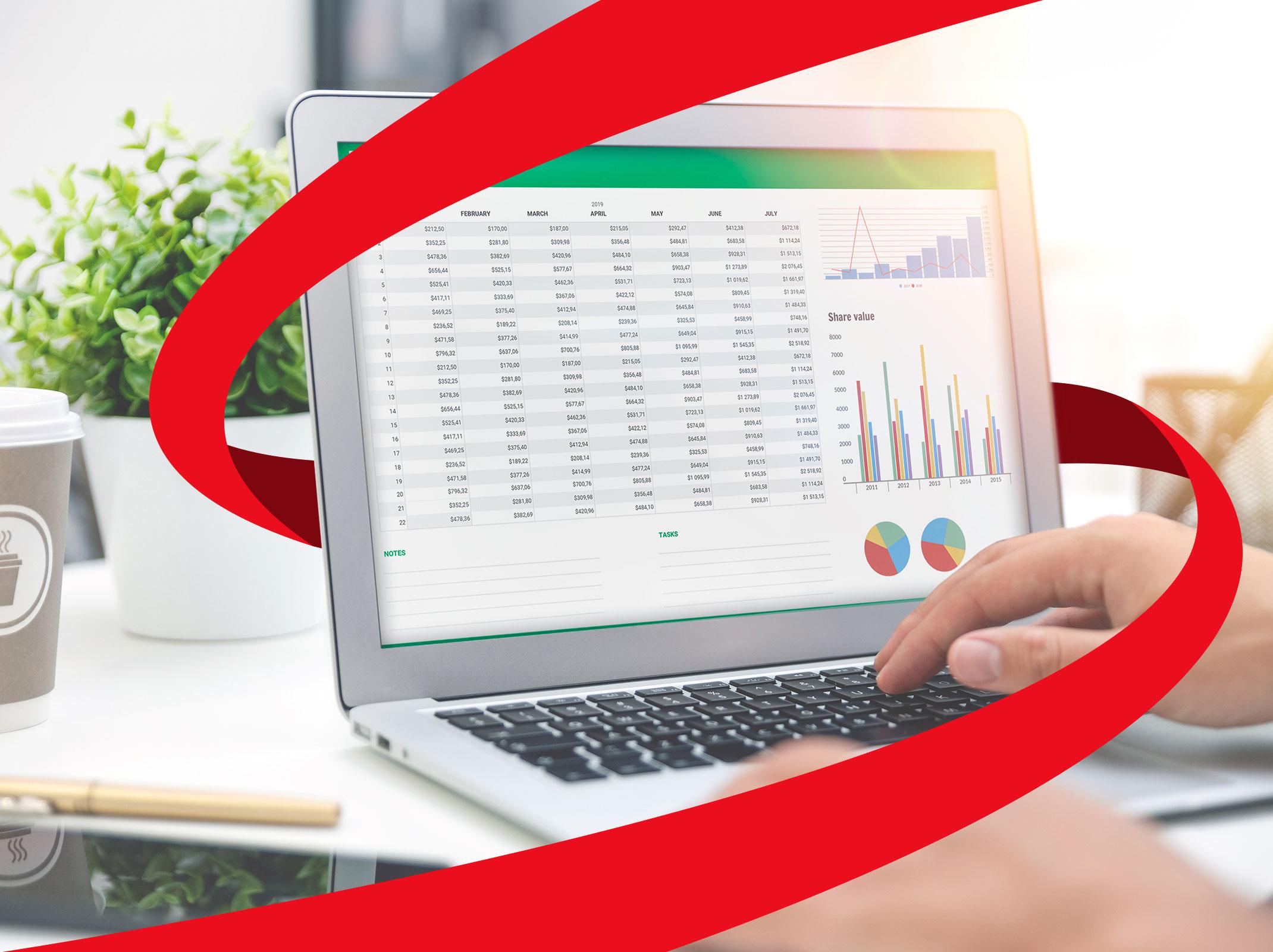 A laptop screen with Microsoft Excel tables and graphs being manipulated by a business person.