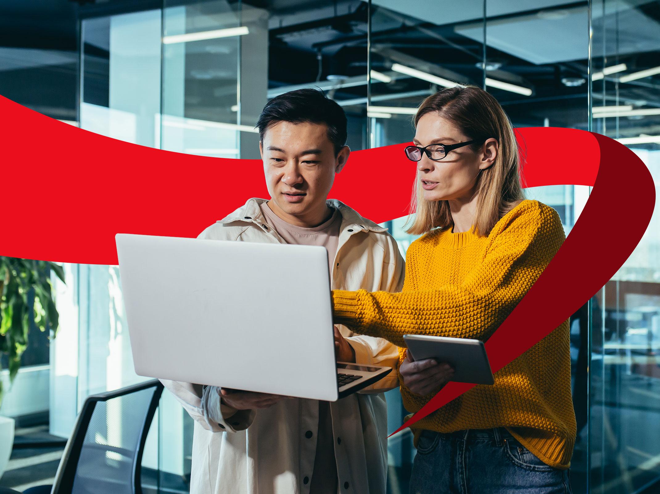 Two accounts payable professionals reviewing information on a laptop