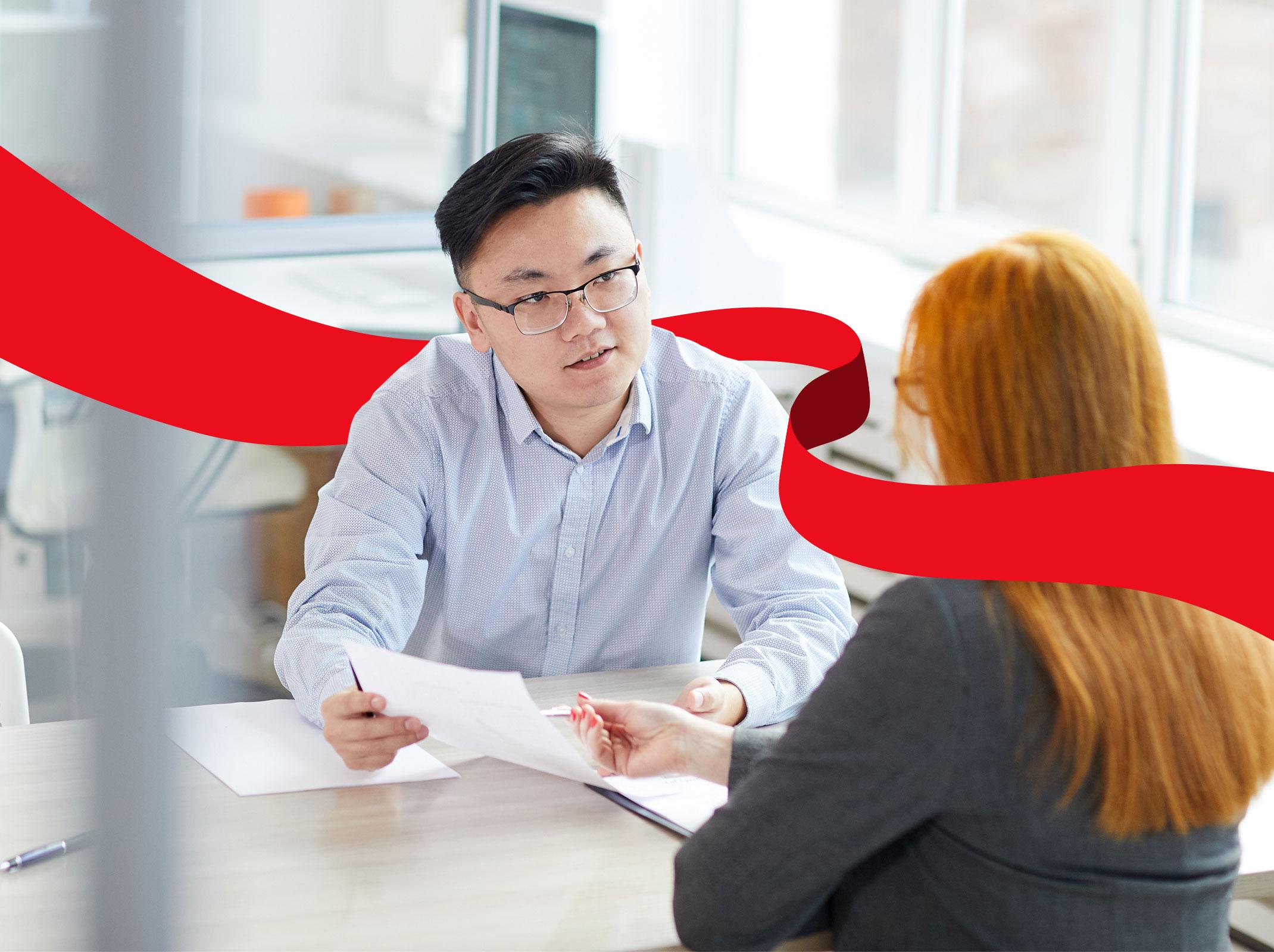 HR professional discussing something with an employee over a conference table