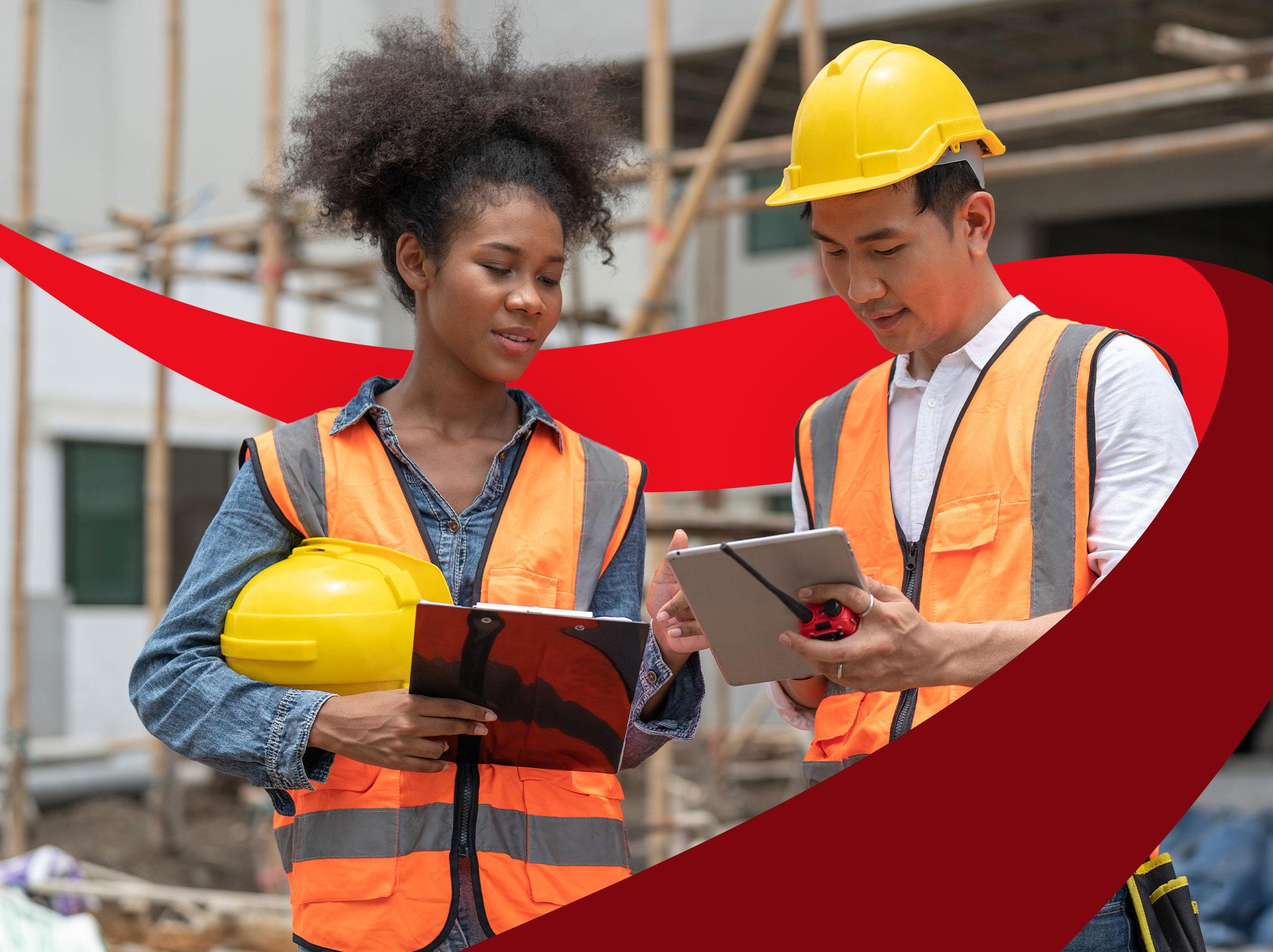 Two people on a construction site wearing safety gear