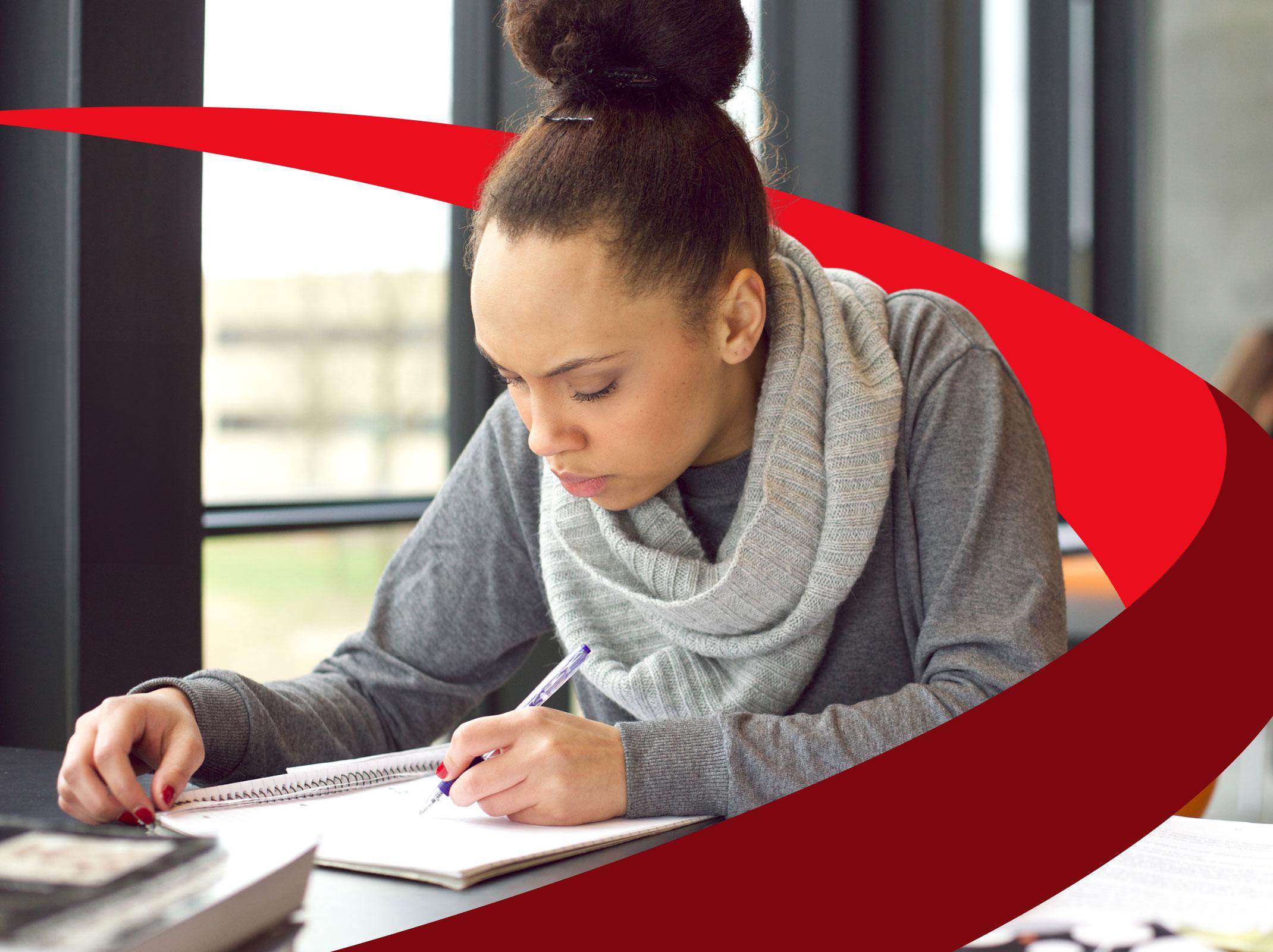 A business professional writing technical business documents in an office setting.
